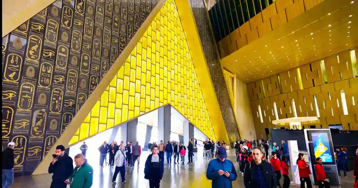 Grand Egyptian Museum atrium and yellow glass facade with visitors