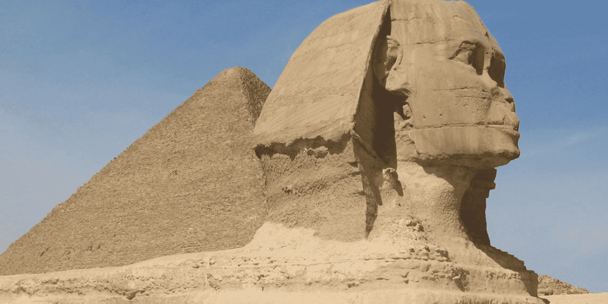 The Sphinx in profile with a pyramid behind