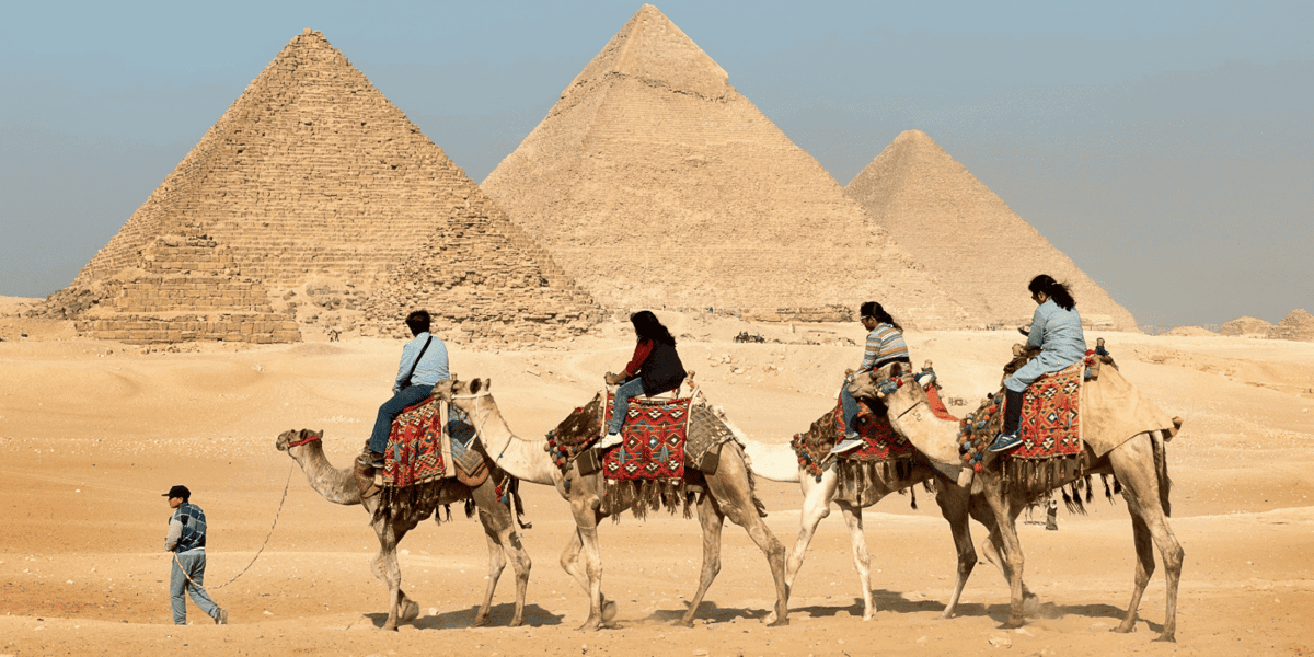 Camel riders in front of the Giza pyramids