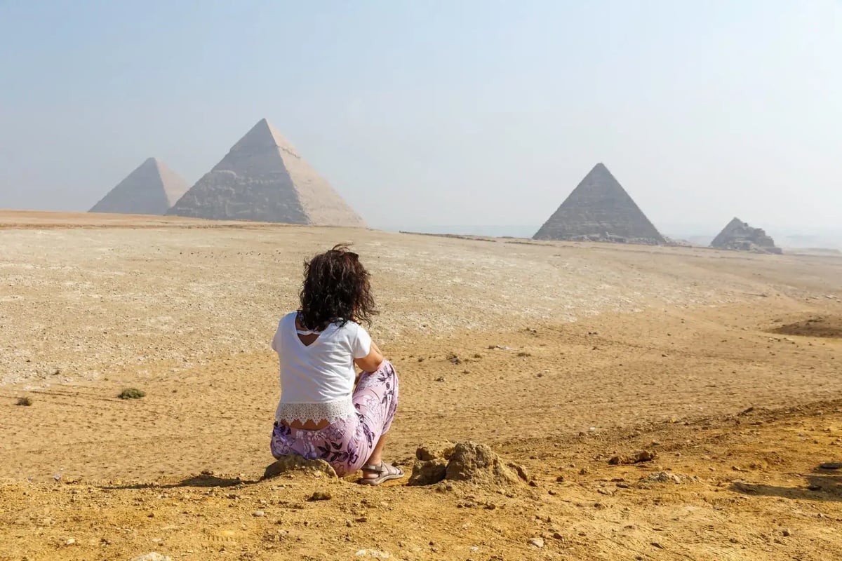 A visitor looking at the pyramids of Giza