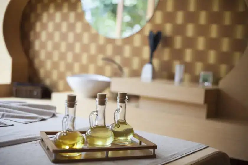 Three glass bottles of massage oil on a tray