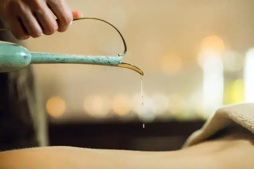 Spa massage oil being poured onto skin