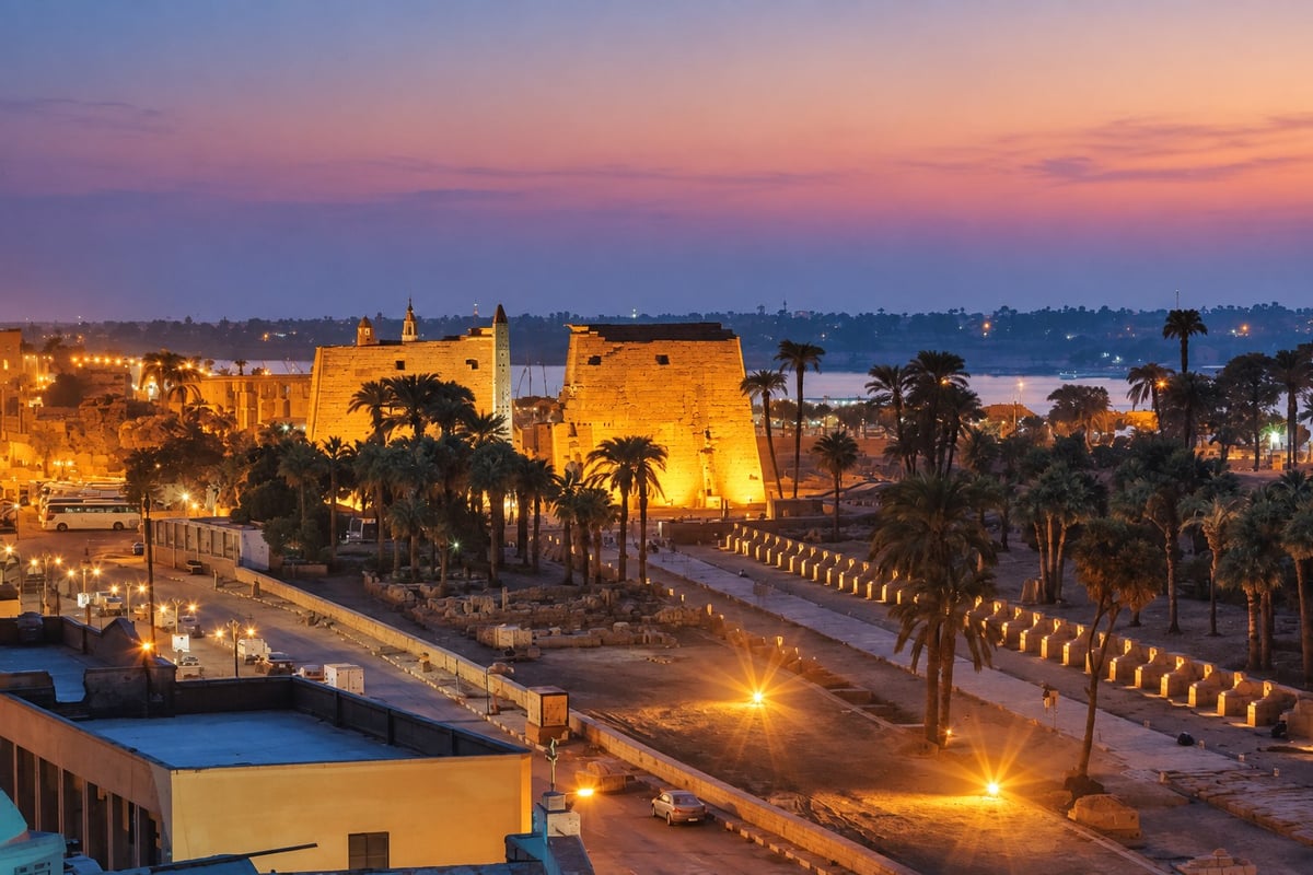 Luxor Temple pylons lit at dusk on the East Bank, Nile visible beyond, Karnak and Luxor Temple tour