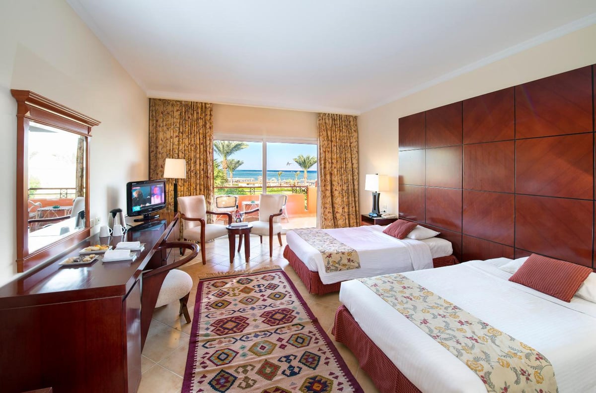 Amwaj Oyoun Resort twin room with two beds and a balcony.