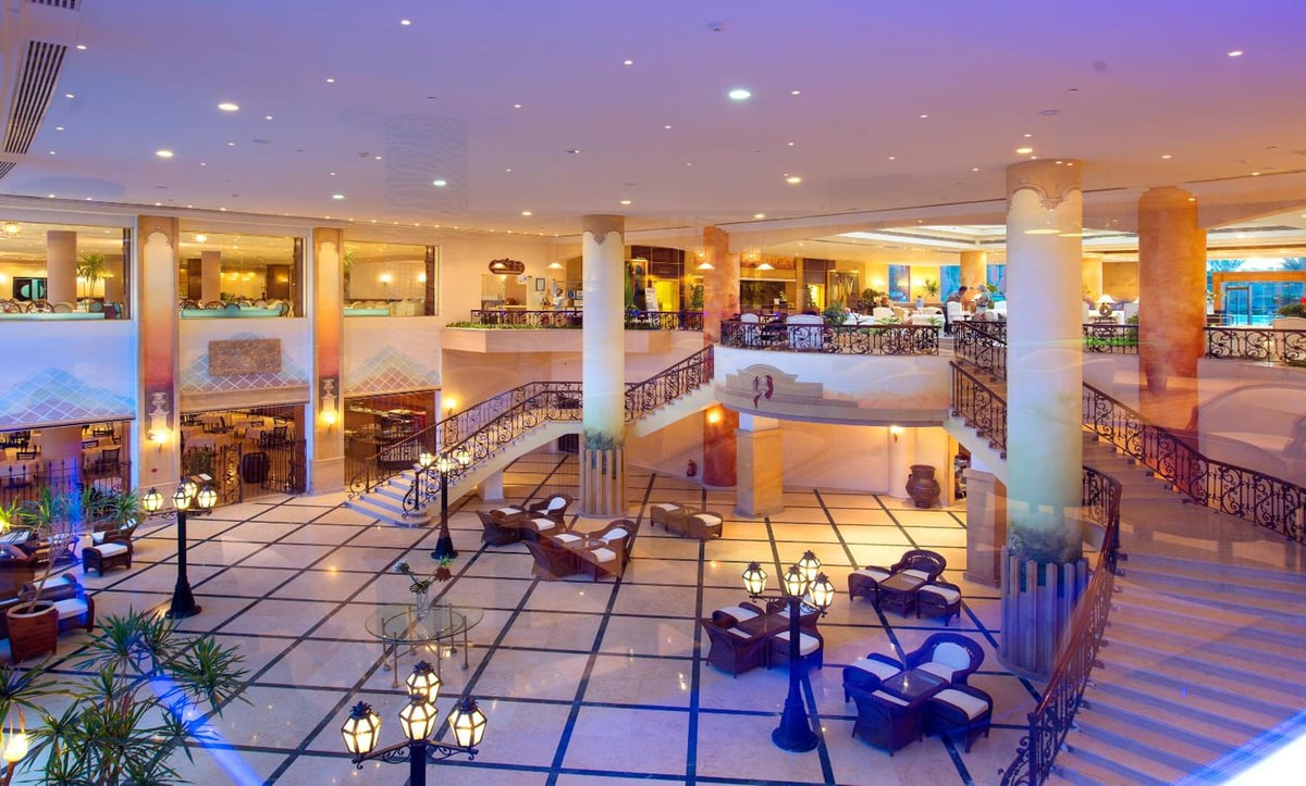 Amwaj Oyoun Resort atrium lobby with curved staircases and seating areas.