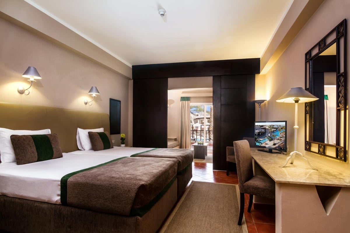 JAZ Makadina guest room with twin beds and a desk.