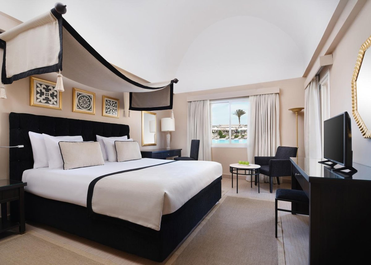 JAZ Makadina guest bedroom with a canopy bed and a large window.