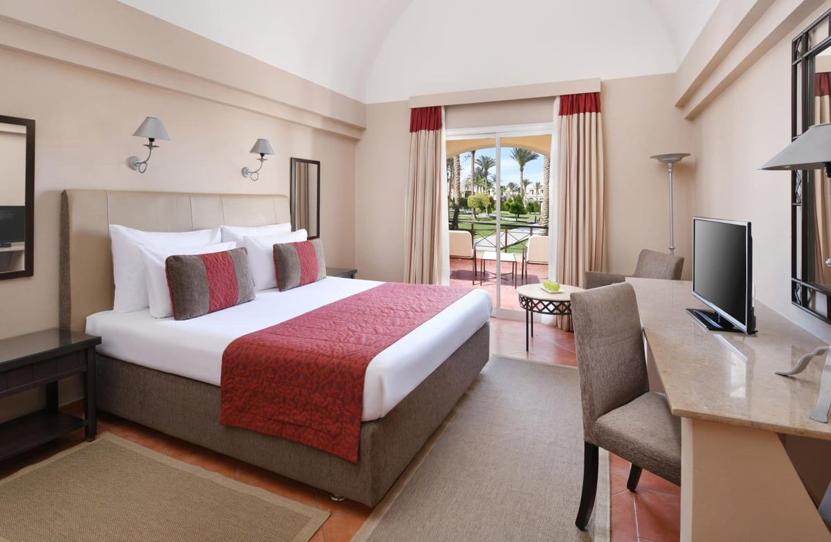 JAZ Makadina bedroom with a large bed and balcony doors.