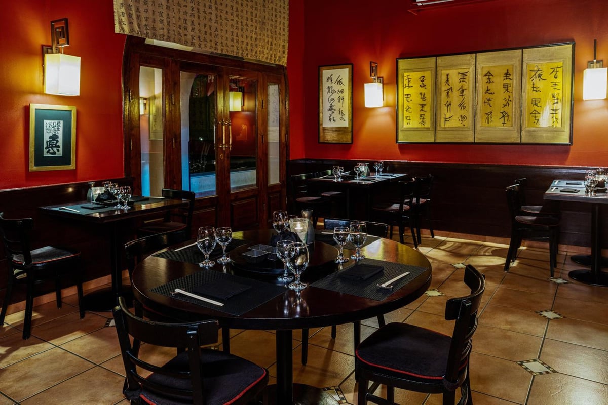 JAZ Makadina dining room with red walls and framed calligraphy.