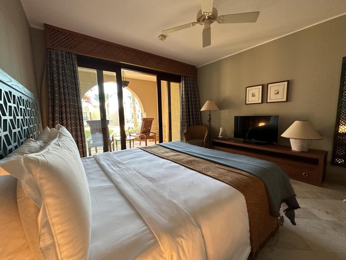 Four Seasons Resort Sharm El Sheikh guest bedroom with a white bed and sliding glass doors to a balcony.