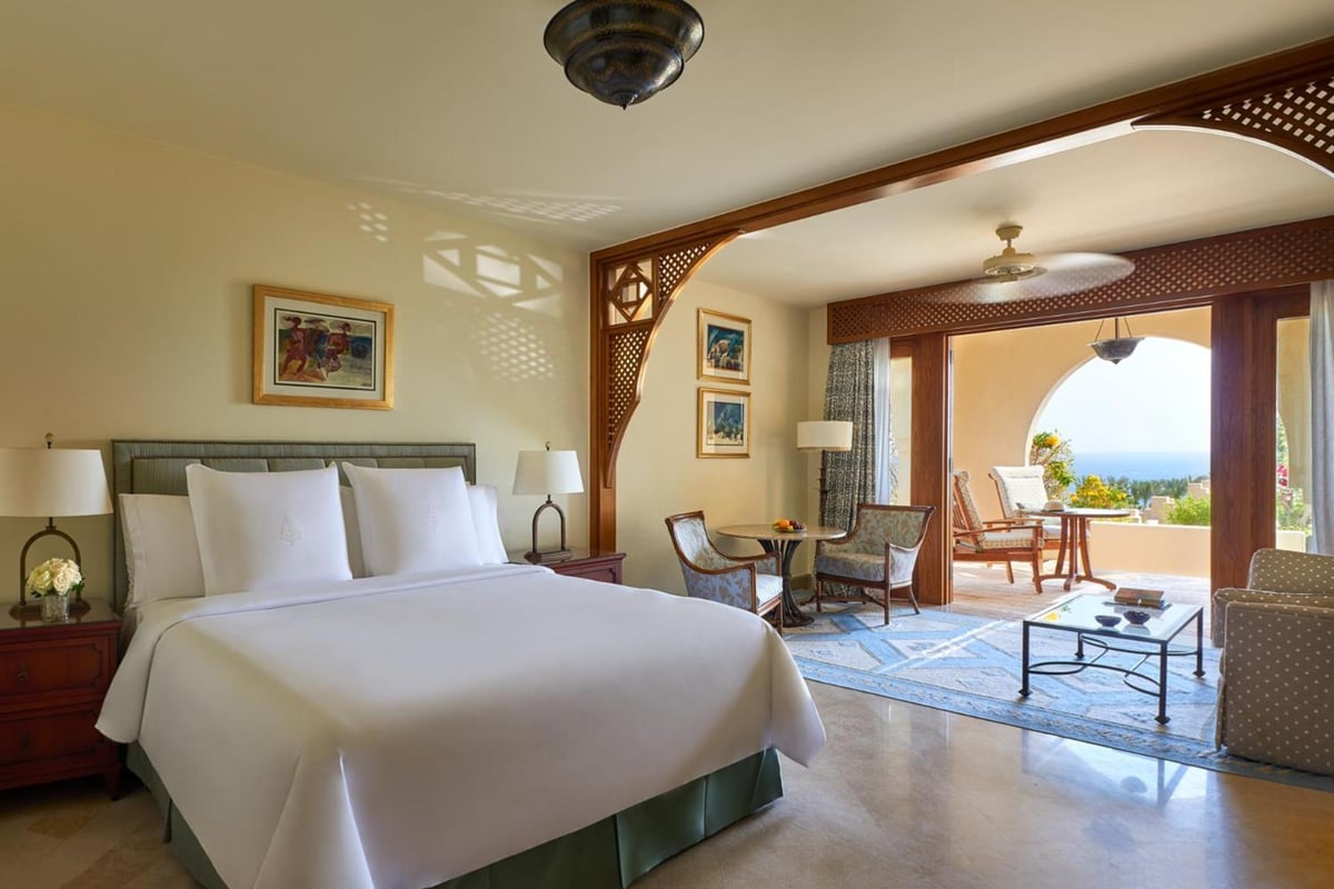 Four Seasons Resort Sharm El Sheikh guest room with a white bed and arched balcony opening.