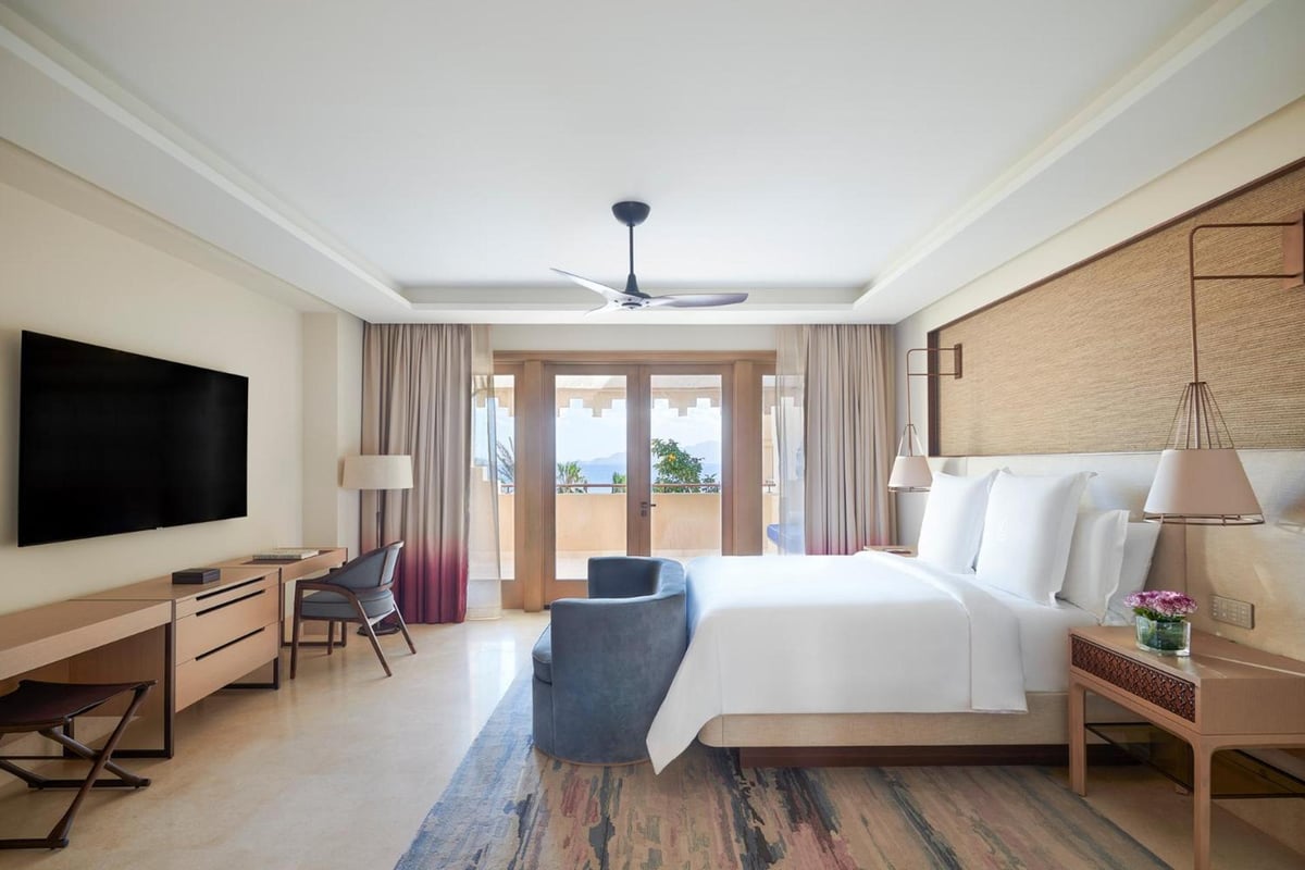 Four Seasons Resort Sharm El Sheikh guest room with a white bed and balcony doors.