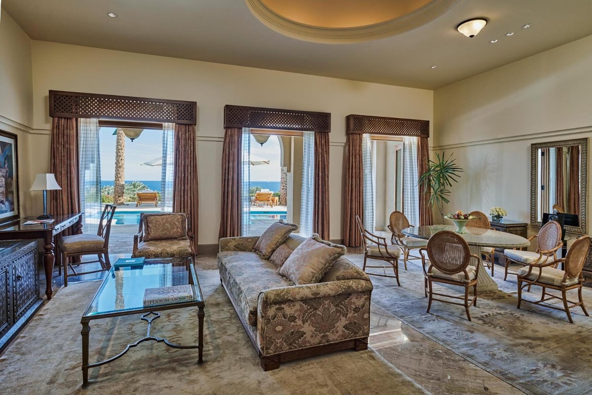 Four Seasons Resort Sharm El Sheikh living room with sea-view windows and a dining area.