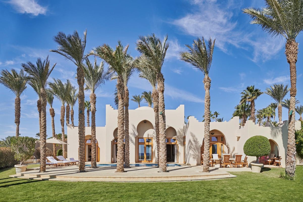 Four Seasons Resort Sharm El Sheikh dining terrace with an arched facade and palm trees.