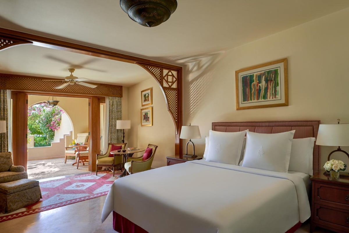 Four Seasons Resort Sharm El Sheikh guest bedroom with a white bed and an arched sitting area.