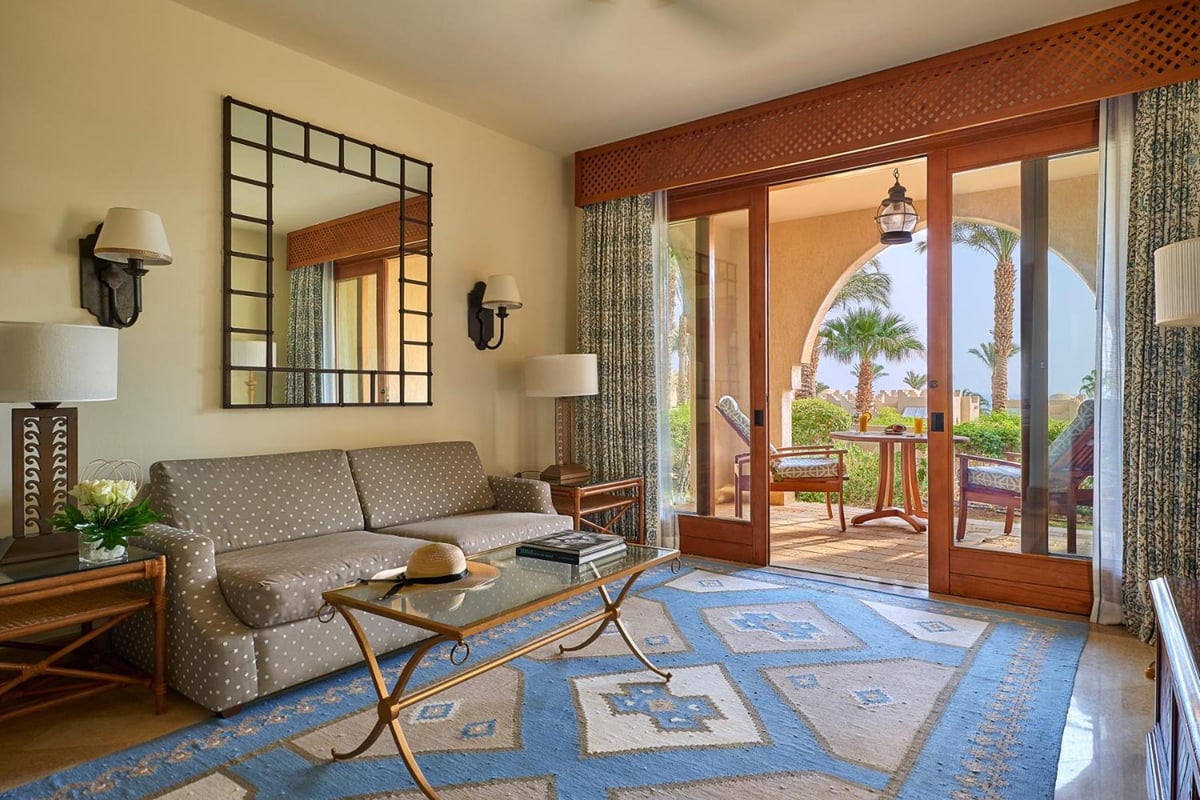 Four Seasons Resort Sharm El Sheikh living room with a patterned sofa and arched glass doors.
