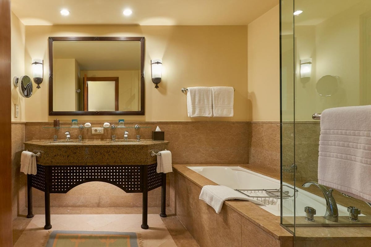 Four Seasons Resort Sharm El Sheikh bathroom with a marble vanity and glass-enclosed bathtub.