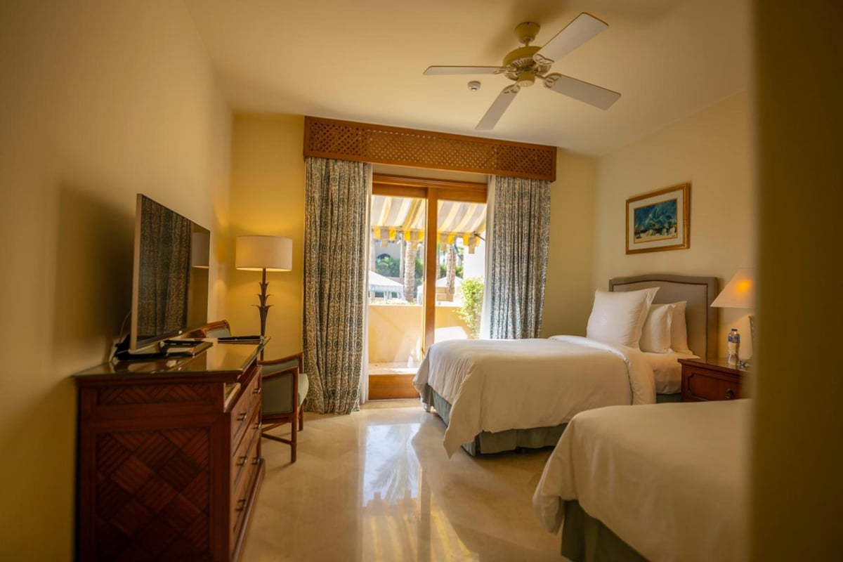 Four Seasons Resort Sharm El Sheikh twin bedroom with two beds and glass balcony doors.