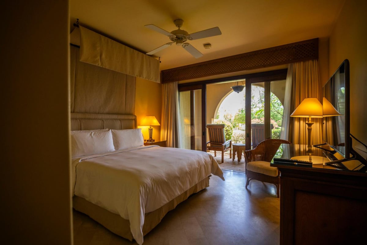 Four Seasons Resort Sharm El Sheikh guest room with a bed and glass doors opening to a patio.