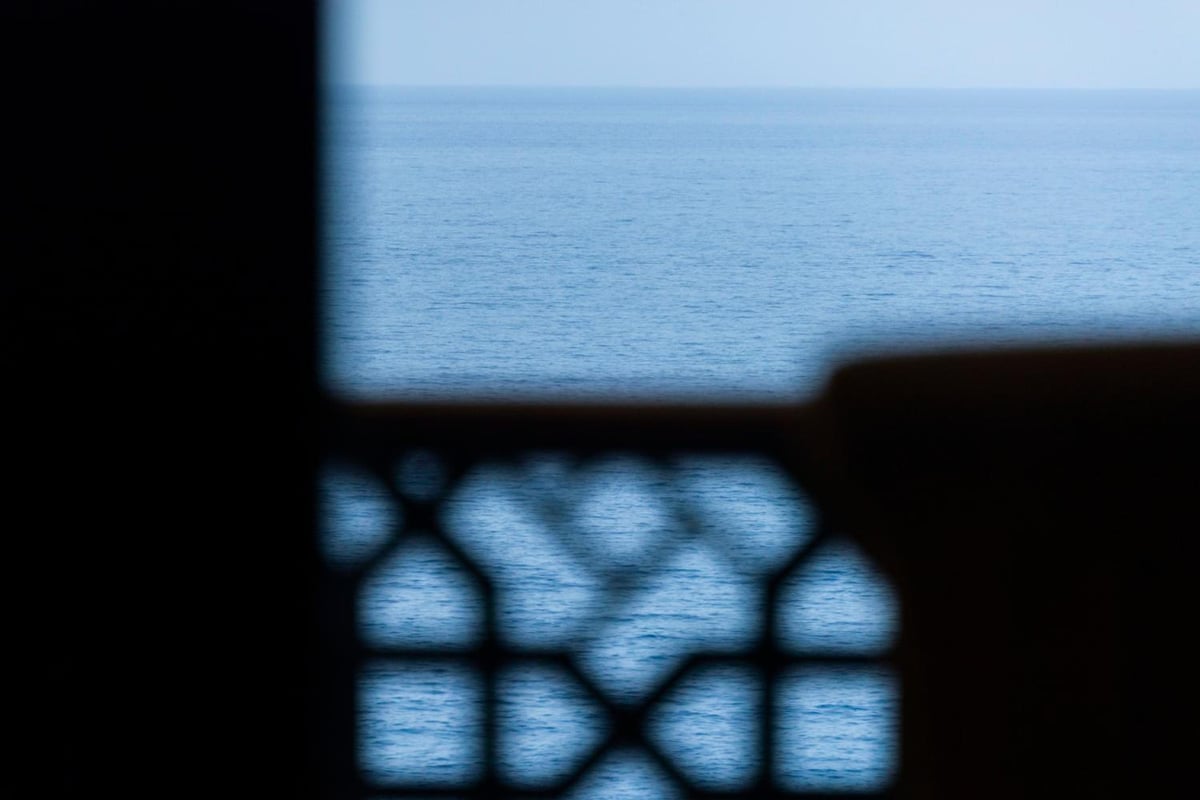 Four Seasons Resort Sharm El Sheikh window with blue sea and a geometric grille.