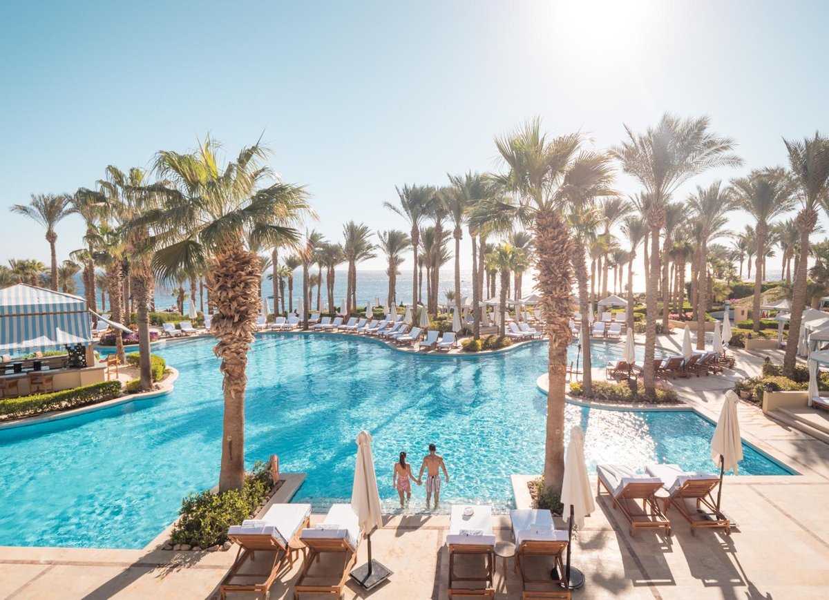 Four Seasons Resort Sharm El Sheikh pool area with palm trees and sun loungers.