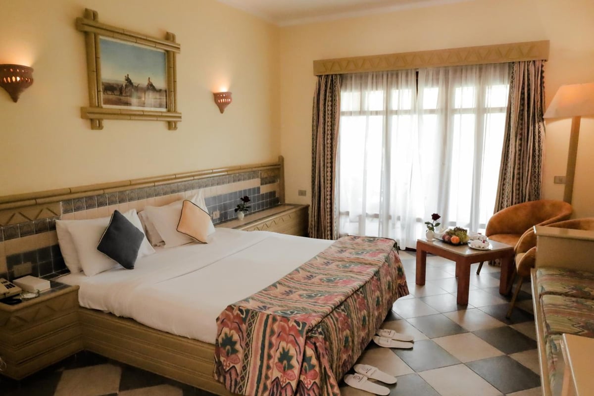 Tropitel Dahab Oasis guest room with a double bed and a seating area.
