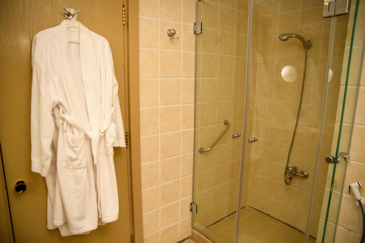 Tropitel Dahab Oasis shower with tiled walls and a glass door.