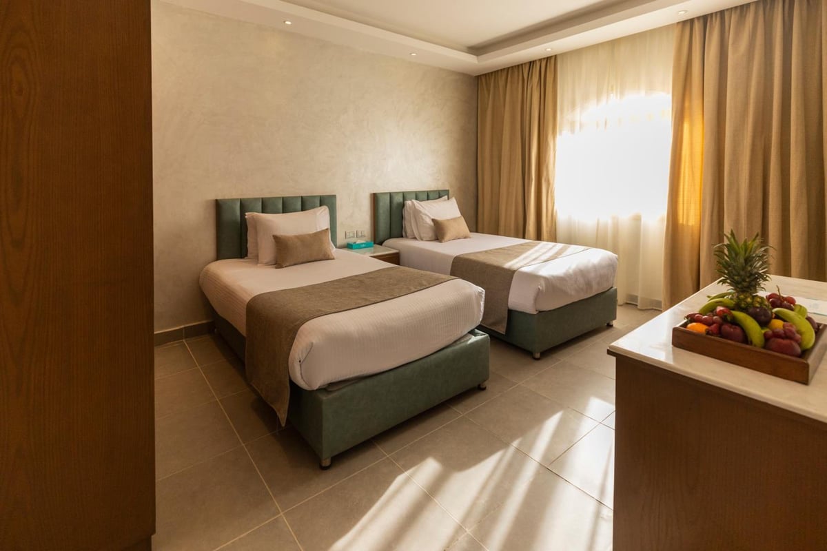 Sunrise Aqua Joy Resort twin bedroom with two beds and a bright window.