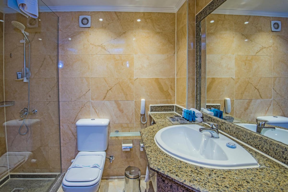 Sunrise Aqua Joy Resort bathroom with a glass shower and granite vanity.