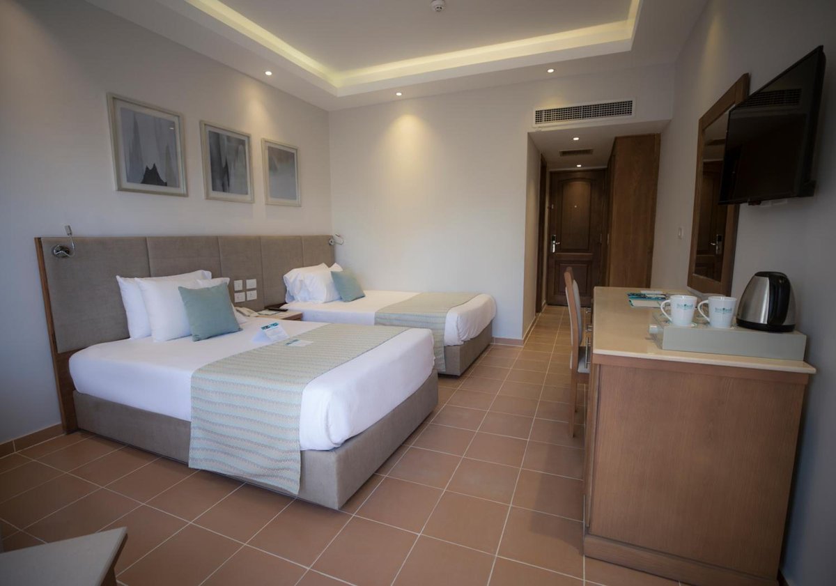 Sunrise Aqua Joy Resort guest room with twin beds and a desk.