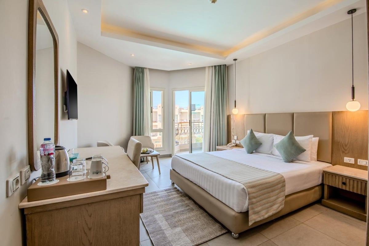 Sunrise Aqua Joy Resort guest room with a double bed and balcony doors.