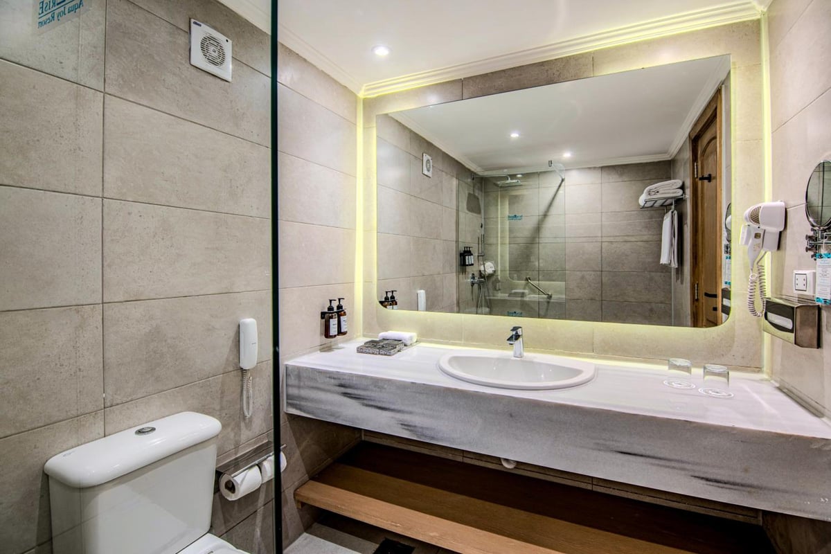 Sunrise Aqua Joy Resort bathroom with a wide mirror and marble vanity.
