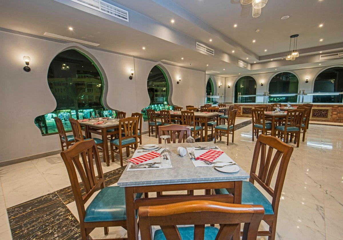 Sunrise Aqua Joy Resort dining room with arched windows and wooden tables.