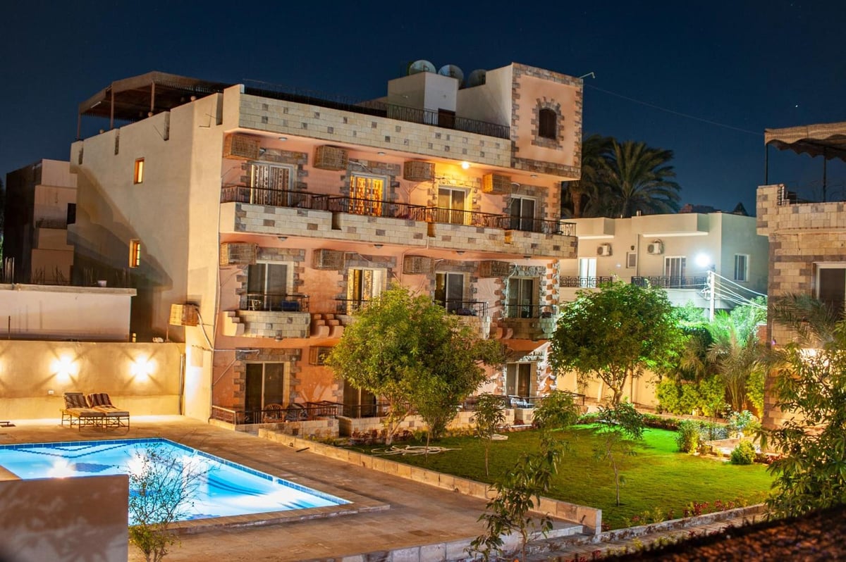 New Memnon Hotel Luxor courtyard with a swimming pool and garden.