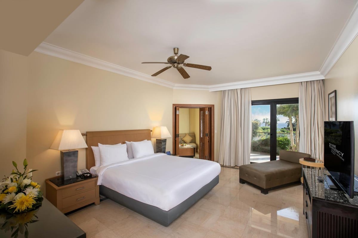 Park Regency Sharm El Sheikh Resort bedroom with a large bed and sliding glass doors.