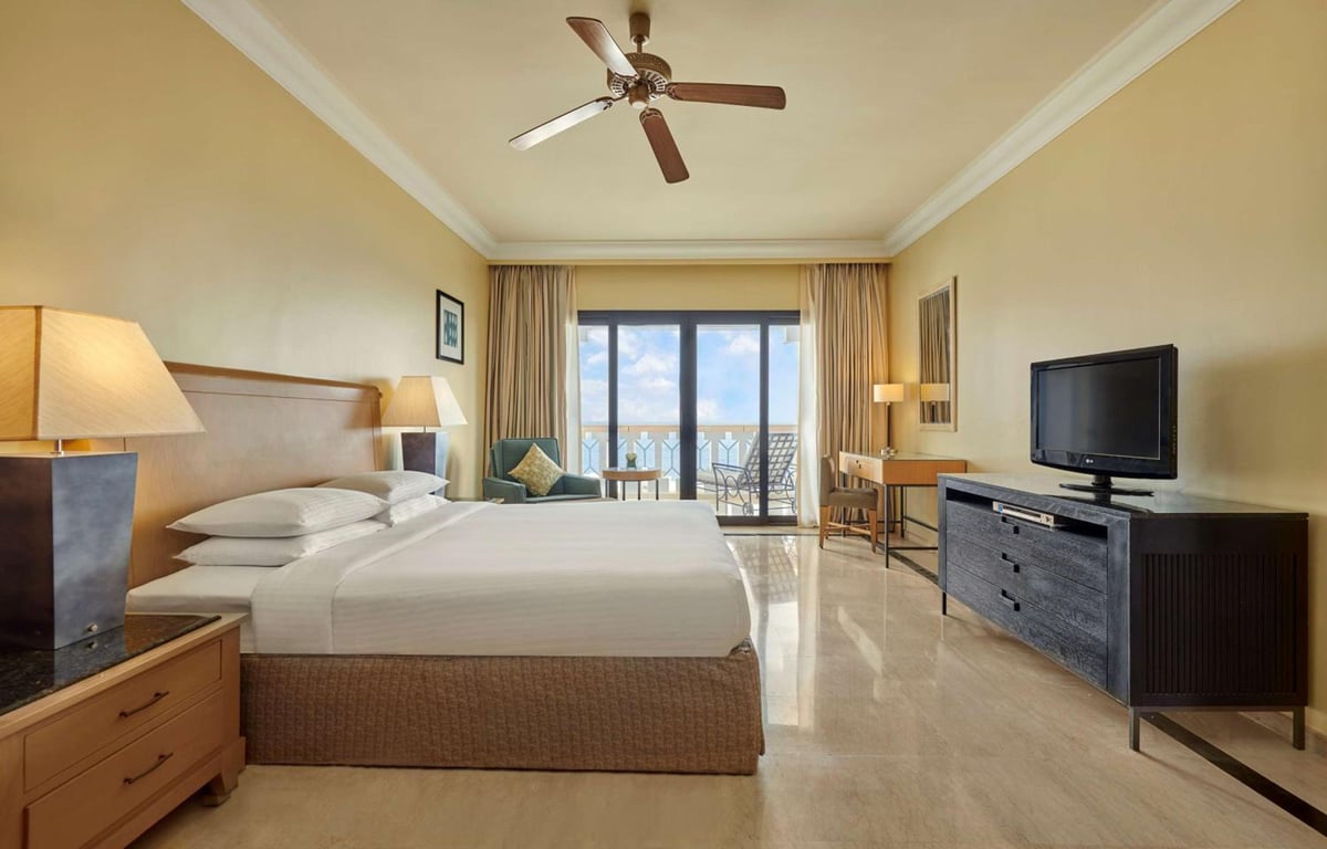 Park Regency Sharm El Sheikh Resort guest room with a bed and balcony doors.
