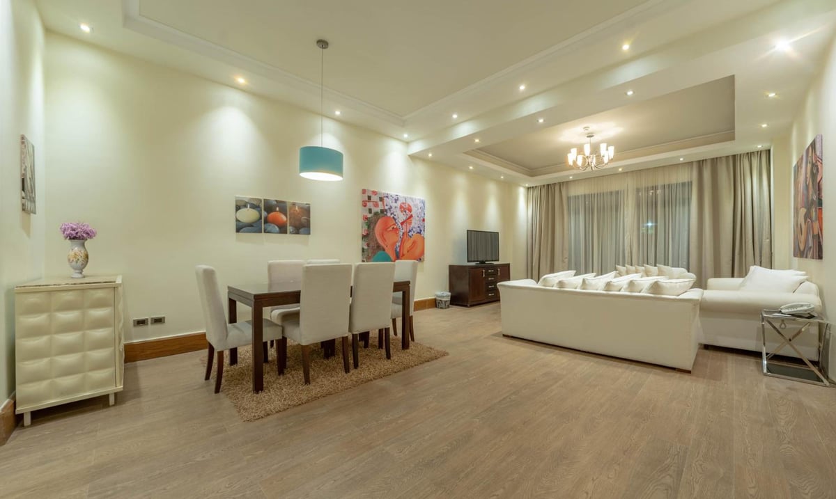 Park Regency Sharm El Sheikh Resort living and dining room with a dining table and cream sofa.
