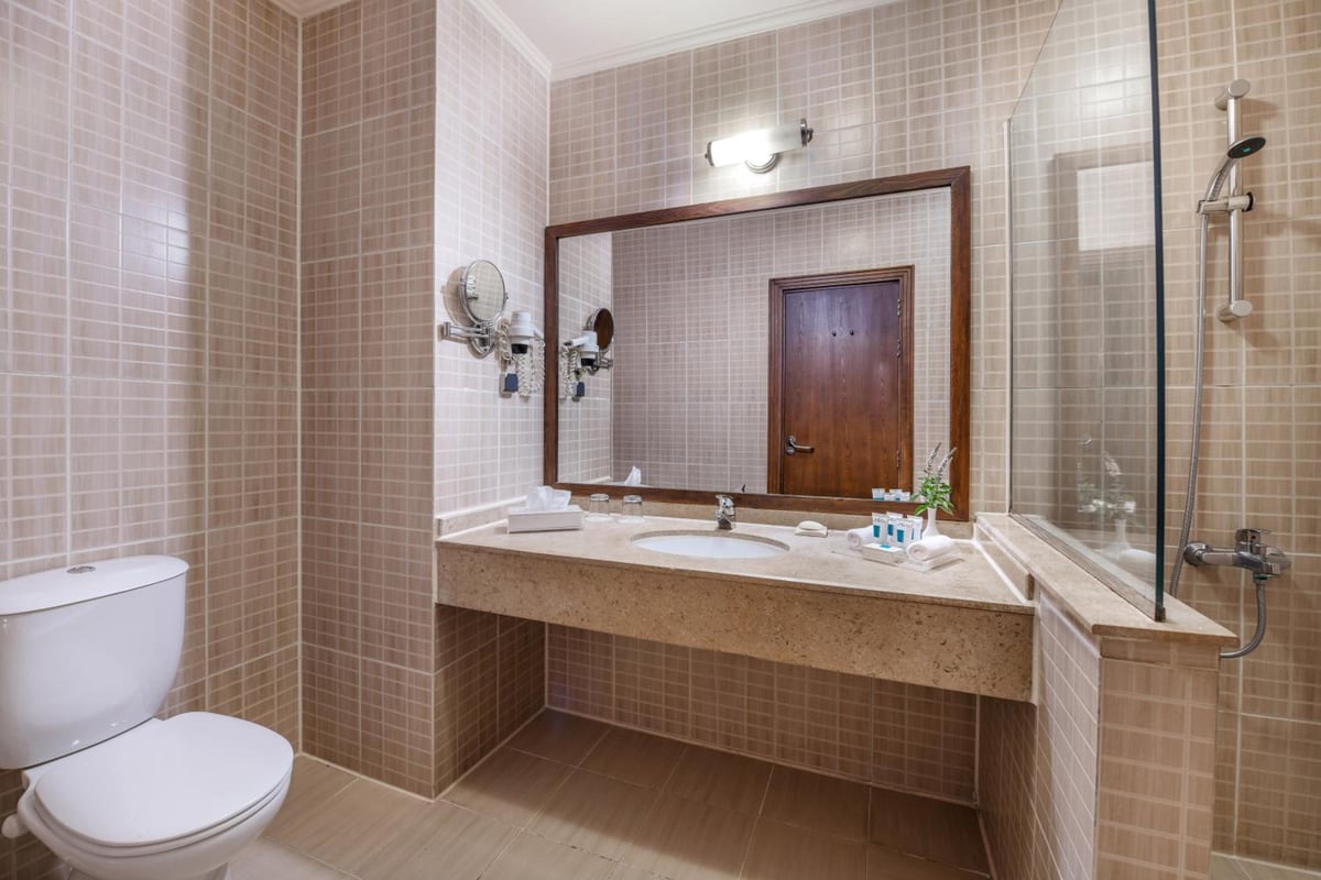 JAZ Dahabeya bathroom with a stone vanity and glass shower.