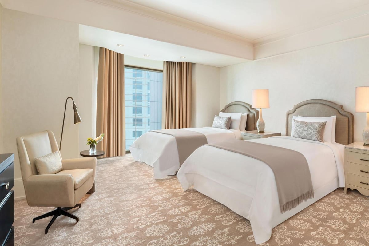 St. Regis Cairo twin bedroom with two beds and a large window.