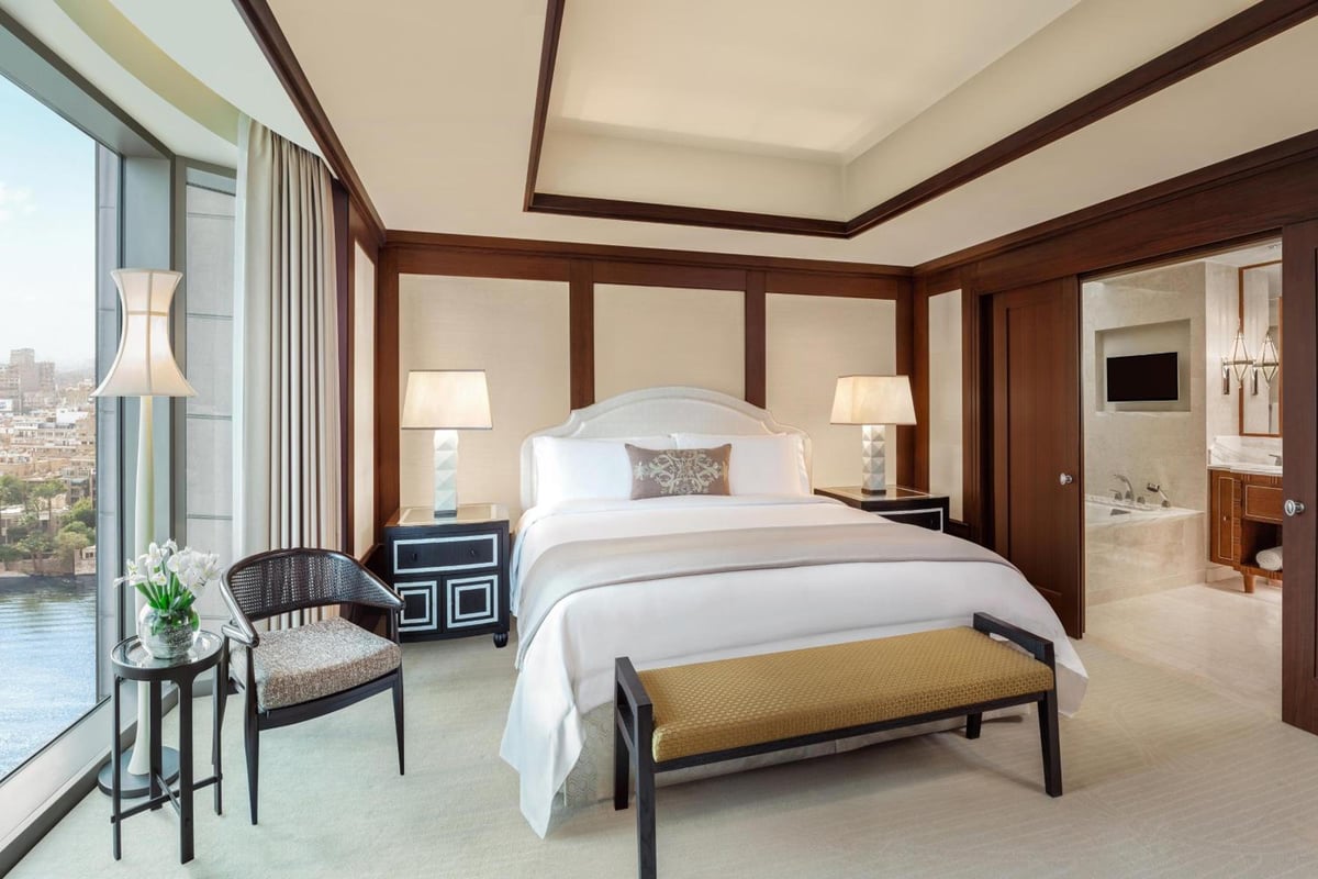 St. Regis Cairo bedroom with a large bed and floor-to-ceiling windows.
