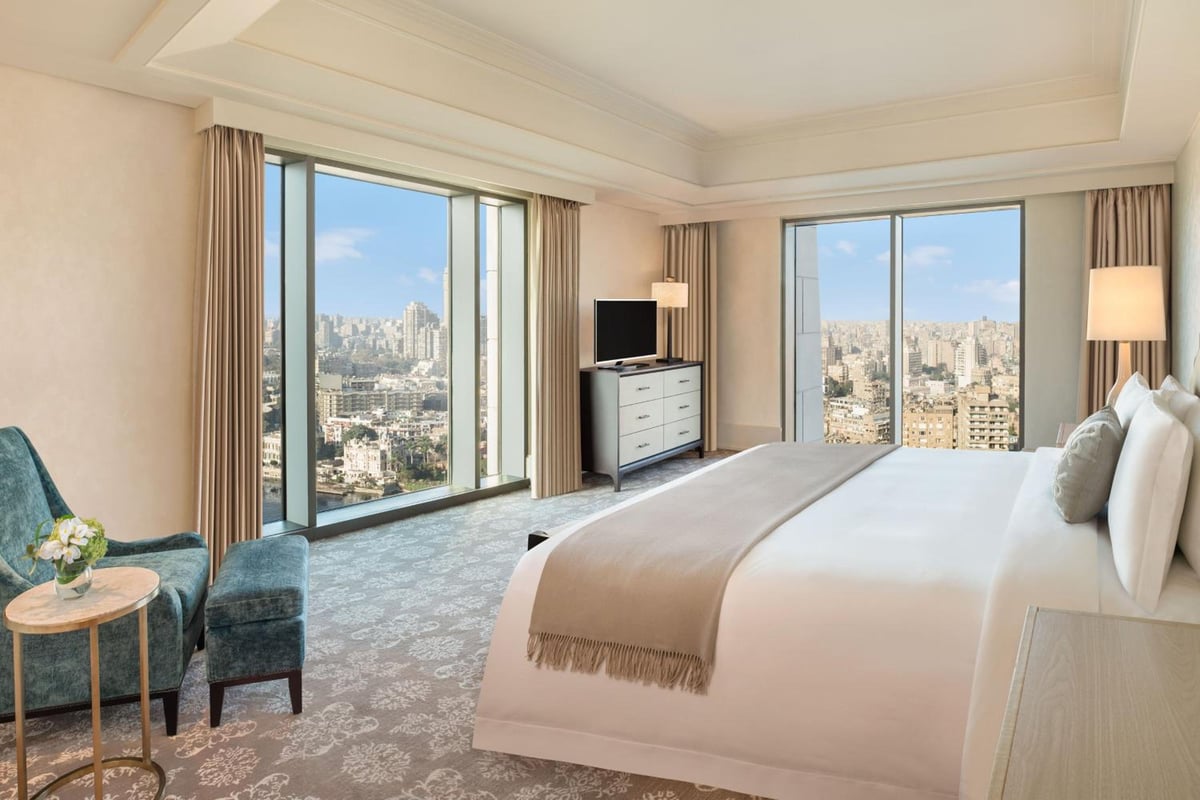 St. Regis Cairo guest bedroom with tall windows and city views.