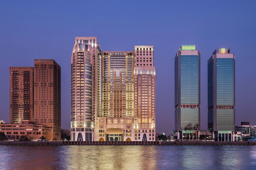 St. Regis Cairo exterior from the river with illuminated riverside facade and adjacent high-rise towers.