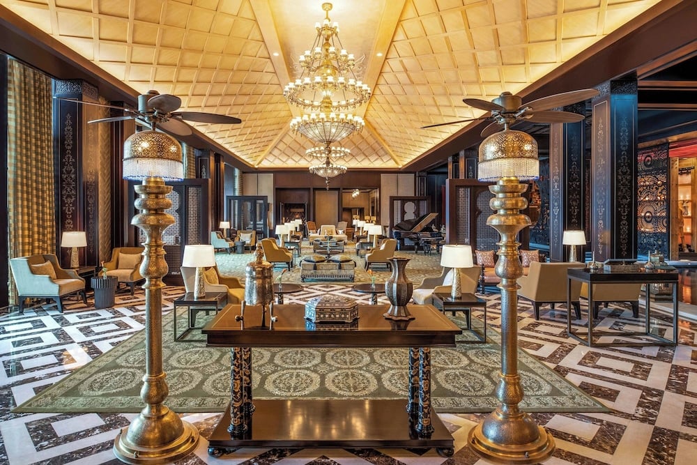 St. Regis Cairo lobby with ornate chandeliers and patterned marble floor.