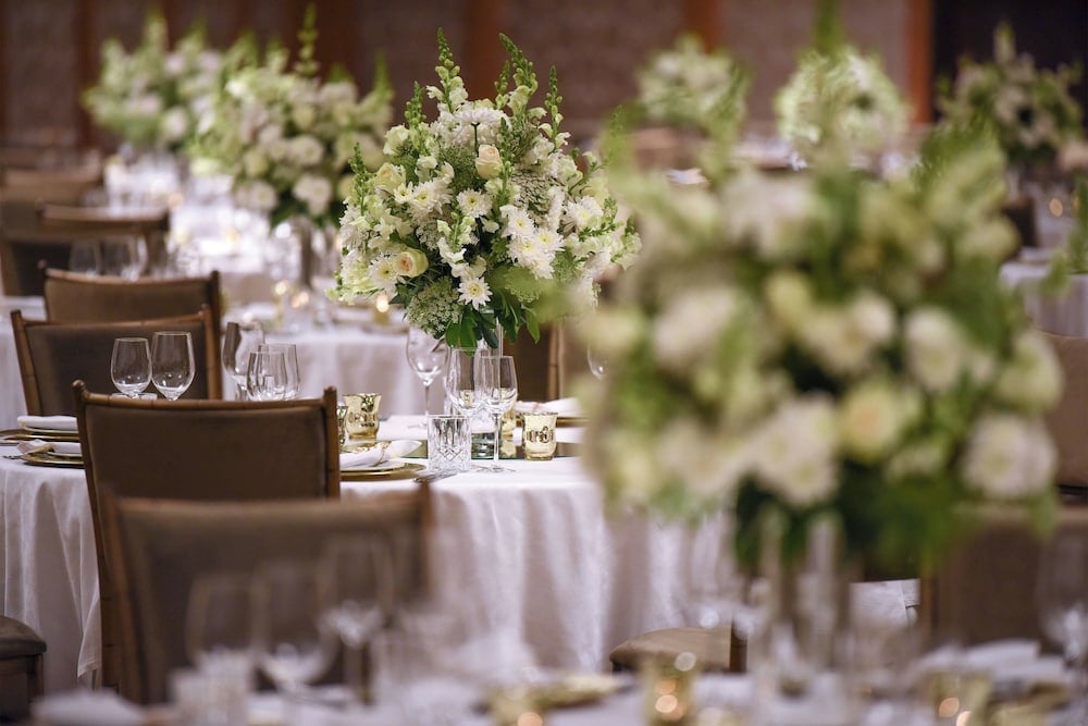 St. Regis Cairo ballroom with round banquet tables and tall white floral centrepieces.