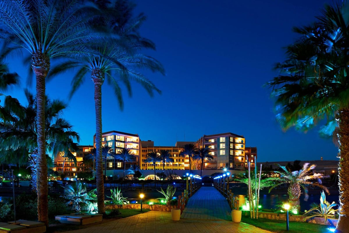 Marriott Hurghada Beach Resort resort exterior night with lit façade and palm-lined pathway.