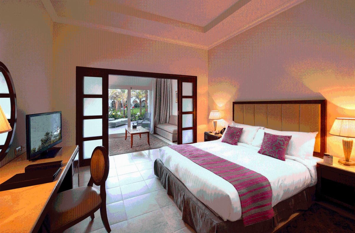 Baron Palace Sahl Hasheesh bedroom with a large bed and open double doors.