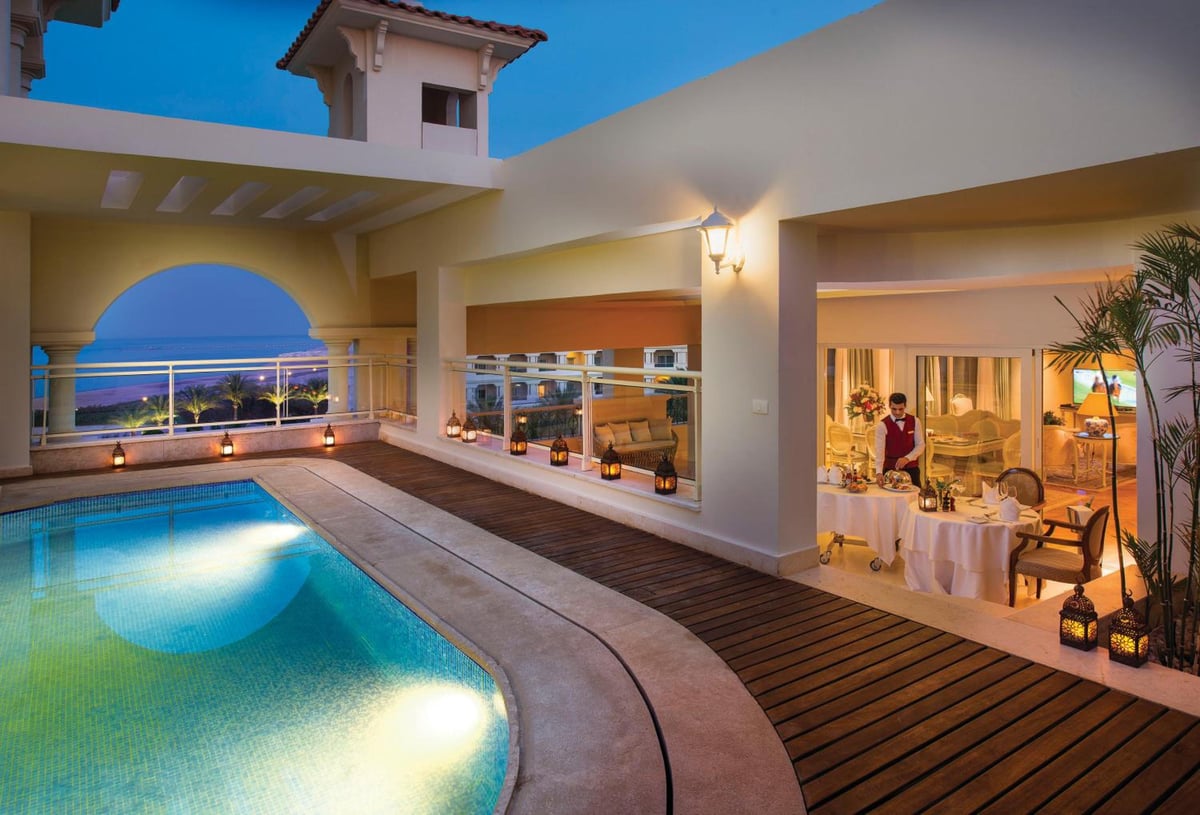 Baron Palace Sahl Hasheesh poolside dining terrace with a curved pool and open-air dining area.