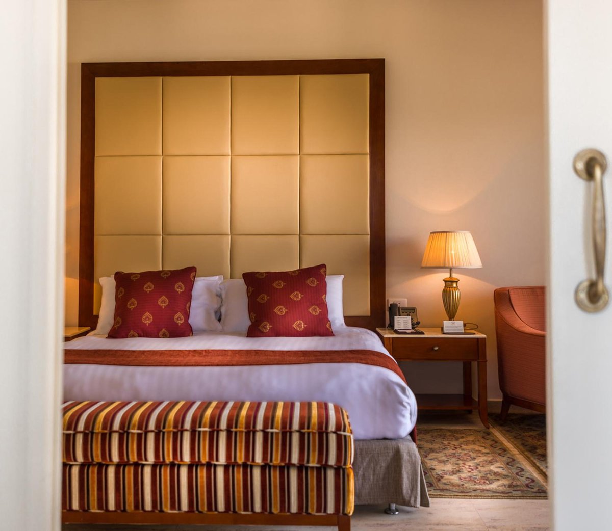 Baron Palace Sahl Hasheesh bedroom with a padded headboard and striped bench.
