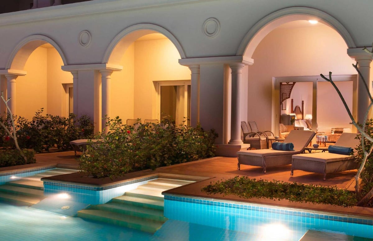 Baron Palace Sahl Hasheesh pool terrace with a tiled pool and arched columns.