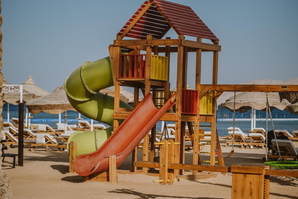 Baron Resort Sharm El Sheikh beach playground with a wooden play structure and slides.